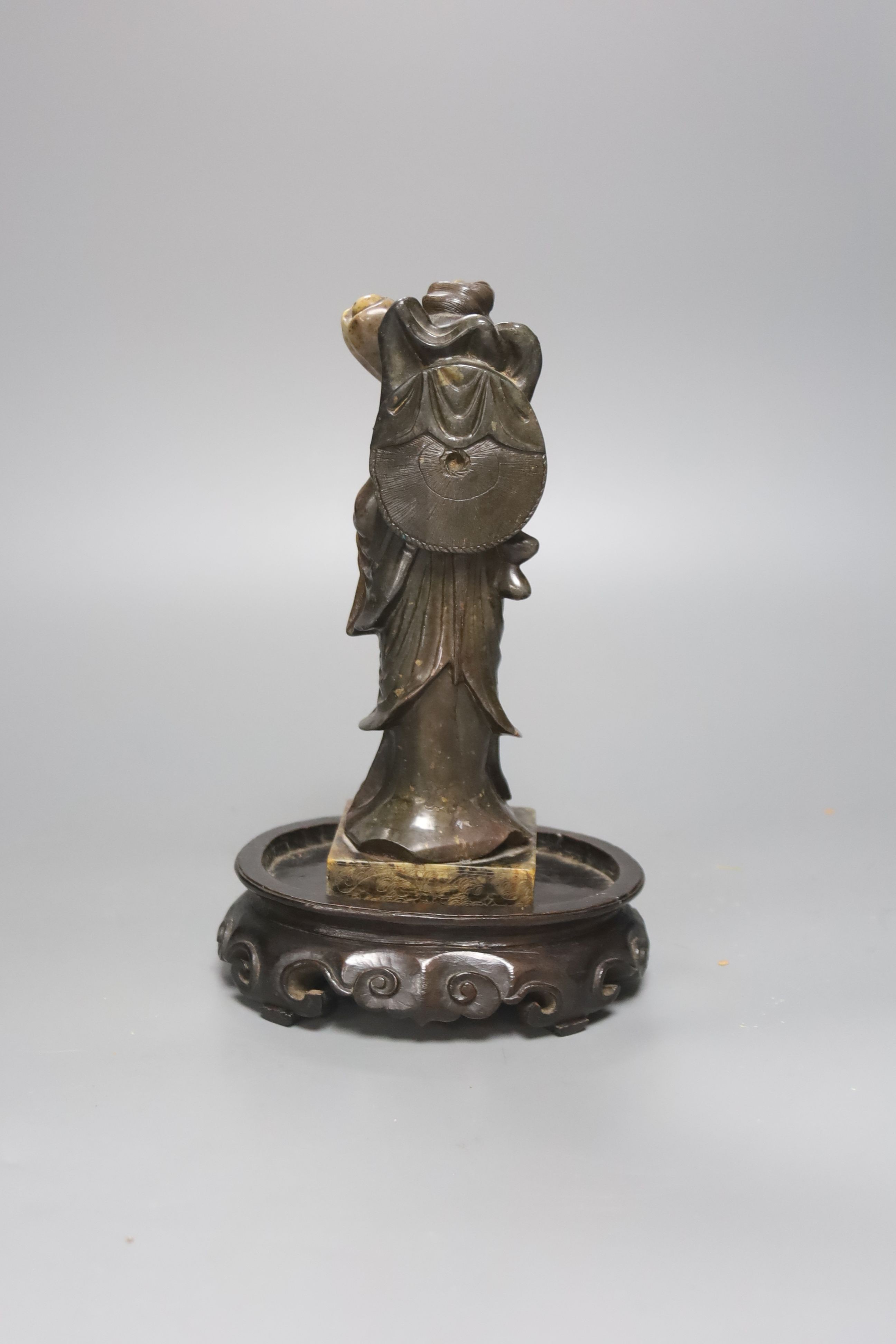 A 19th century Chinese soapstone figure of He Xiangu, associated wood stand 19cm